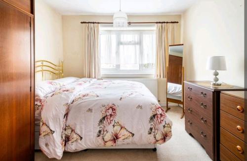 伦敦London Stratford Holiday Home的一间卧室配有一张床、一个梳妆台和一扇窗户。