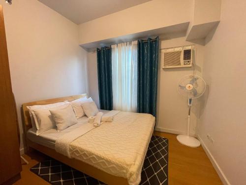 马尼拉8 Adriatico的一间卧室配有一张带风扇和窗户的床。