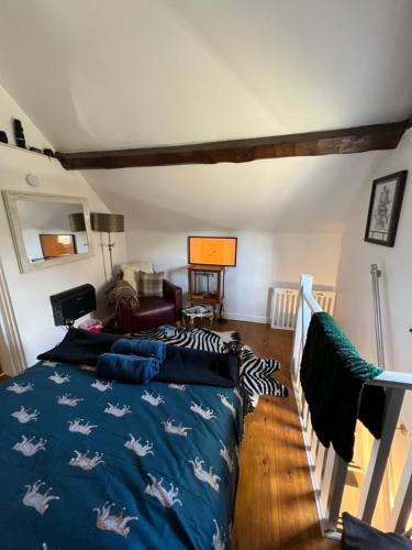 MadeleyThe Hanging Gate Coach House的一间卧室配有一张带蓝色毯子和马的床铺。