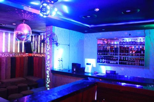 哈科特港Rocket Room Hotel & Suites Limited的一间拥有蓝色灯光和吧台的酒吧