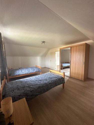 CominesTHE 11 gîte pour vacances ou travail的一间卧室设有两张床,铺有木地板