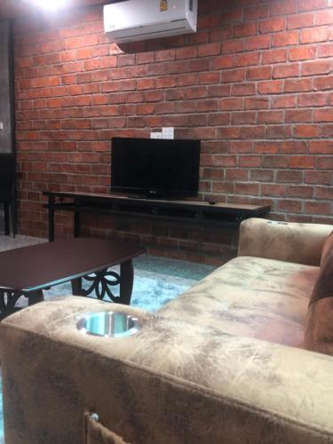 Koh Loneแครินโฮมสเตร์的客厅配有沙发和带电视的桌子