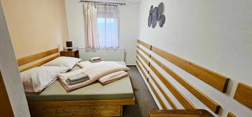 赫任斯科Penzion u Marešů的一间小卧室,配有两张床和窗户