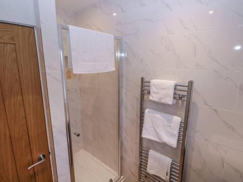 阿什伯恩Walnut Lodge的带淋浴和白色毛巾的浴室