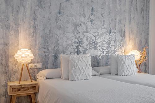 洛斯卡尼奥斯德梅卡Labreña Hotel的卧室配有带白色枕头和壁纸的床