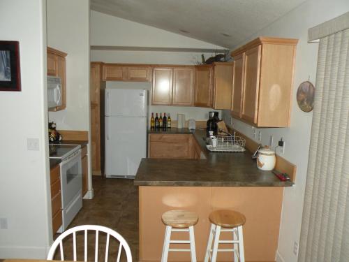 拉派恩松树舒适度假屋的厨房配有柜台和2张凳子