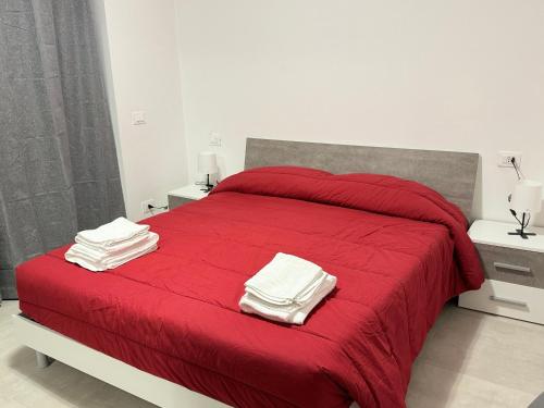 AteletaAffittacamere “In Piazzetta”的一间卧室配有红色的床和毛巾