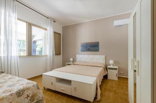 普罗斯西托角Casa vacanze Tafuro的一间白色卧室,配有两张床和窗户