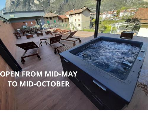 加尔达湖滨Garda Family & Solarium的庭院里设有大型按摩浴缸和椅子