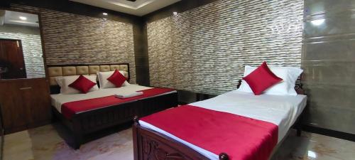 瓦朗加尔Supreme Hotels 2.0的一间卧室配有两张带红色枕头的床