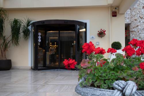 马诺卡尔扎蒂都耶托丽贝尔席多酒店的大堂,在大楼前有红色的鲜花