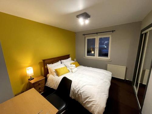 阿伯丁Aberdeen Beach 2 Bed Apartment的一间卧室配有一张床、一张书桌和一个窗户。