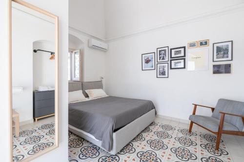 佩斯基奇Minimà Peschici的一间卧室配有一张床、一把椅子和镜子