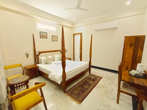 阿格拉Gupta Vilas - A Boutique Homestay的一间卧室配有一张床、一把椅子和一张书桌