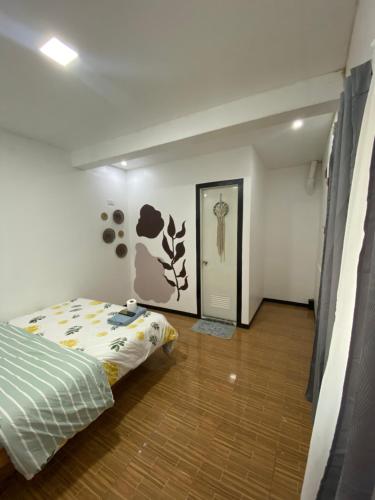 莫阿尔博阿TopBudz Hostel Panagsama Moalboal Couple的一间卧室设有一张床,走廊设有门