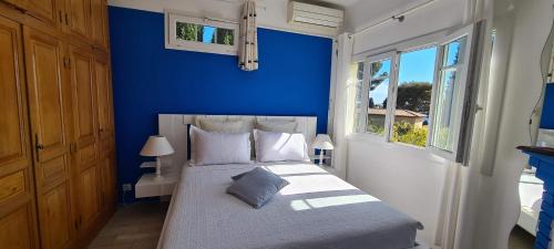 勒·雷约尔·卡纳德尔·苏尔Villa Adriandre的蓝色的卧室,配有一张蓝色墙壁的床