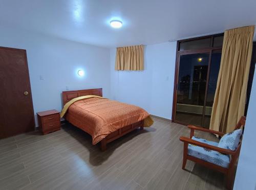 瓦拉斯LOS NEVADOS II的卧室配有床、椅子和窗户。