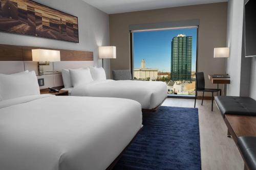 奥斯汀AC Hotel by Marriott Austin-University的酒店客房设有两张床和大窗户。