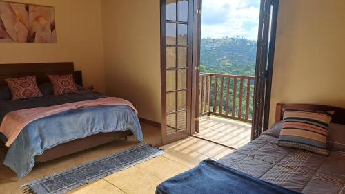 坎波斯杜若尔当Casa Sossego na Montanha的一间卧室设有一张床和一个阳台