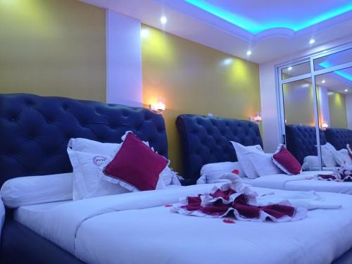 雅温得Matcheu palace Hôtel的客房配有两张带紫色和白色枕头的床。