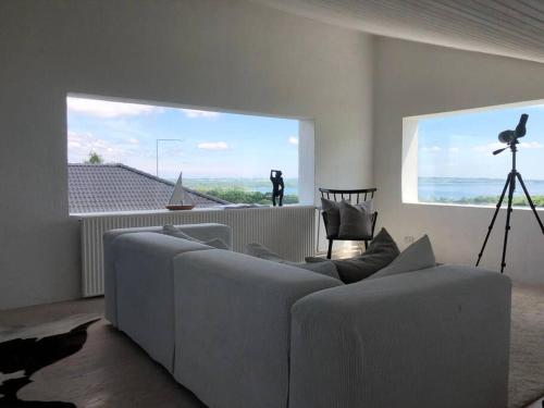 伦德Luxury house with breathtaking sea view of Mols的带沙发和大窗户的客厅
