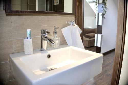 萨拉热窝Sarajevo Sky Suite的浴室设有白色水槽和镜子