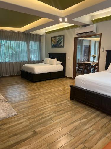 巴亚尔塔港South Shore Villa Armonia Luxury Boutique的一间卧室设有两张床,铺有木地板