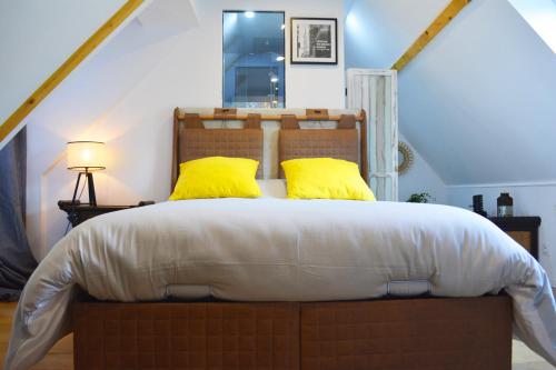 圣阿韦尔坦Manoir Drissia - Tours Centre, France的一间卧室配有一张带黄色枕头的大床
