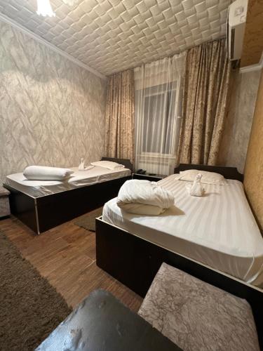 QarasūTet-A-Tet的带窗帘的客房内的两张单人床