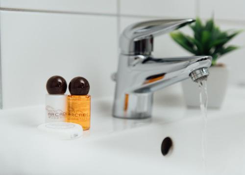 伍珀塔尔阿尔卡德酒店的浴室水槽配有水龙头和1瓶肥皂