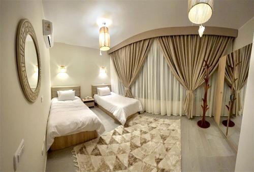 赫尔格达Luxury Villa Bali Al Gouna Hurgh的酒店客房,设有两张床和镜子
