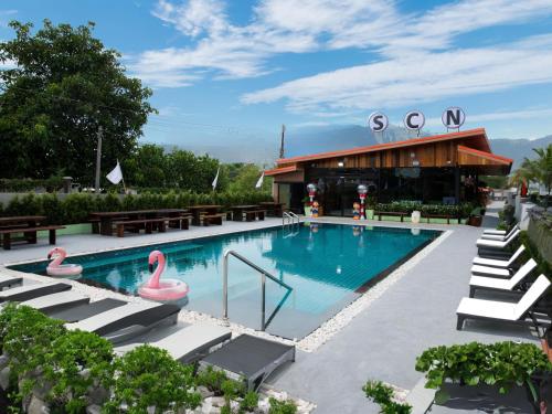 班昌SCN Pet-friendly Hotel โรงแรมรับสัตว์เลี้ยง的一座游泳池,在大楼里设有粉红色的火烈鸟