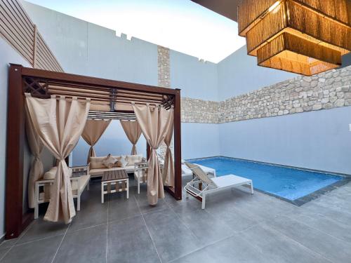 赫尔格达Luxury Villa Bali Al Gouna Hurgh的配有桌椅和游泳池的客房