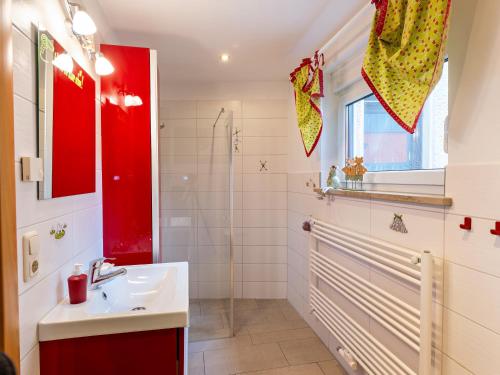 巴特尚道Ferienhaus am Ringweg的一间带水槽和红色橱柜的浴室