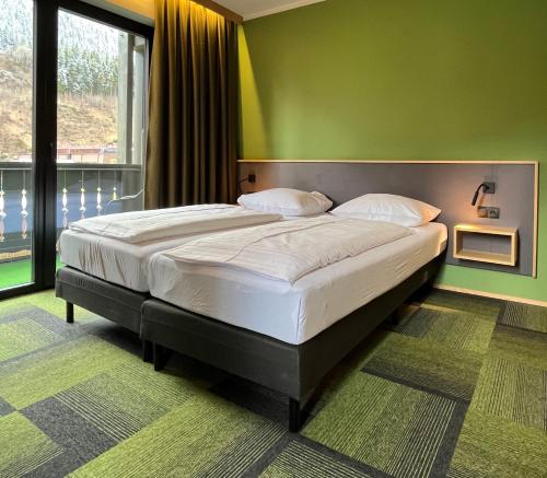巴德加斯坦Hotel Simader的一张大床,位于一个绿色的墙壁内