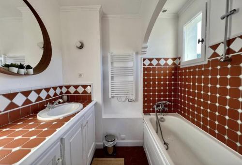 格里莫One Palm的一间带水槽、浴缸和镜子的浴室