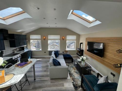 KildwickApartment in North Yorkshire (Crosshills)的带沙发的客厅和带天窗的厨房。