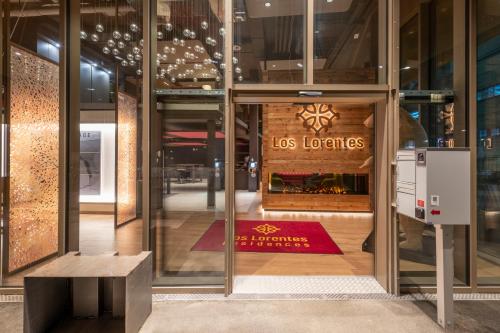 伯尔尼NEW OPENING 2022 - Los Lorentes Hotel Bern City的门上带有lorenos标志的玻璃建筑
