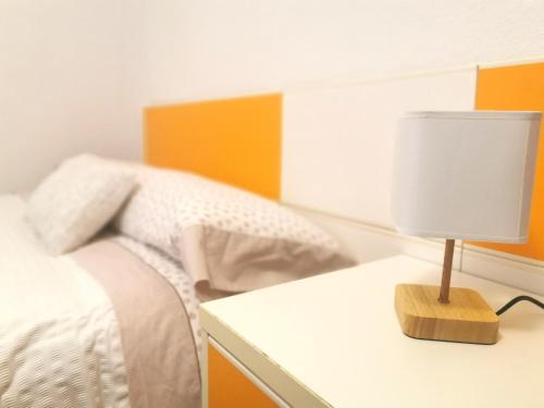 马里亚诺Habitación cerca del aeropuerto的一间卧室配有一张床和一张带台灯的桌子