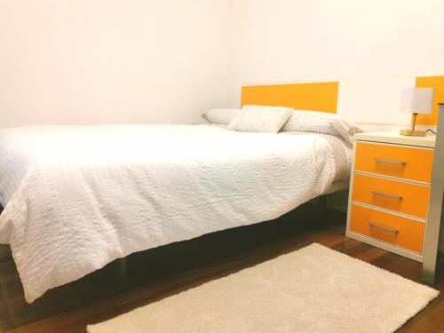 马里亚诺Habitación cerca del aeropuerto的卧室配有白色的床和床头柜