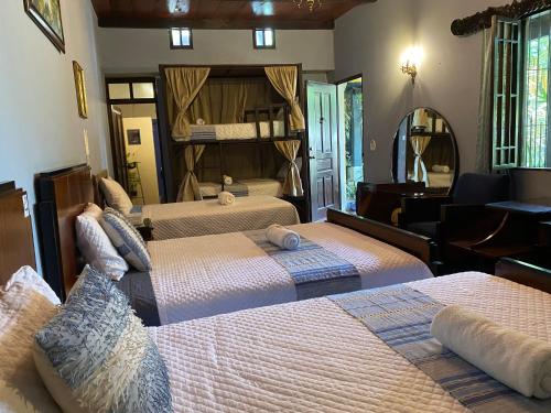 危地马拉安地瓜RUAJ HOSTAL -Wellness-Colonial-Exclusive-的一间卧室配有两张床和镜子