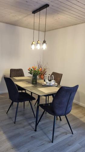 RødekroAnnes Hus的餐桌、椅子和鲜花桌