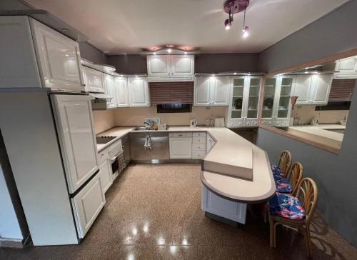 开罗Cairo modern apartment的厨房配有白色橱柜和桌椅