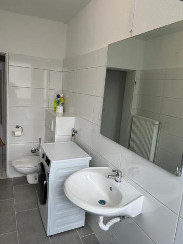 汉诺威Othman Appartements Anderter Straße 55g, 1 OG L的白色的浴室设有水槽和镜子