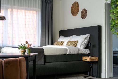 德科赫Hotel Beatrix的一间卧室配有一张床、一张桌子和一个窗户。