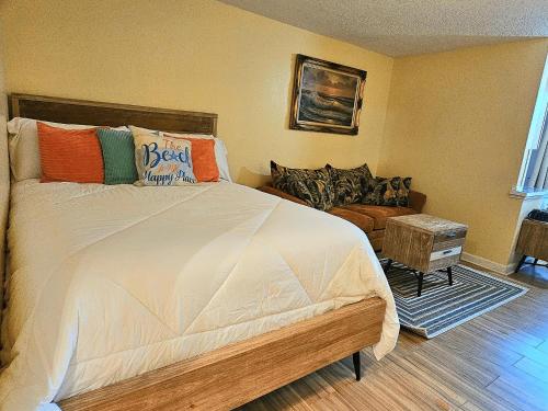 代托纳海滩Oceanfront Escape With Balcony and heated salt water pool!的一间卧室配有一张带色彩缤纷枕头的大床