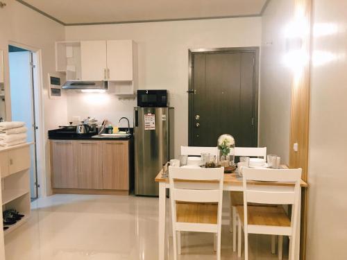 公主港Cozy Condo Palawan的厨房配有桌椅