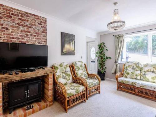 诺丁汉Forest side cottage的客厅配有2把椅子和平面电视