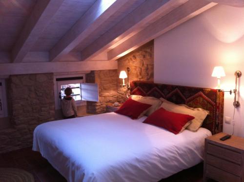 蓬特拉雷纳埃尔奇科酒店的卧室配有带红色枕头的大型白色床