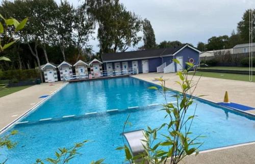 BeltonSwift Retreat - Haven Wild Duck Holiday Park的一座大型蓝色游泳池,设有一排小屋